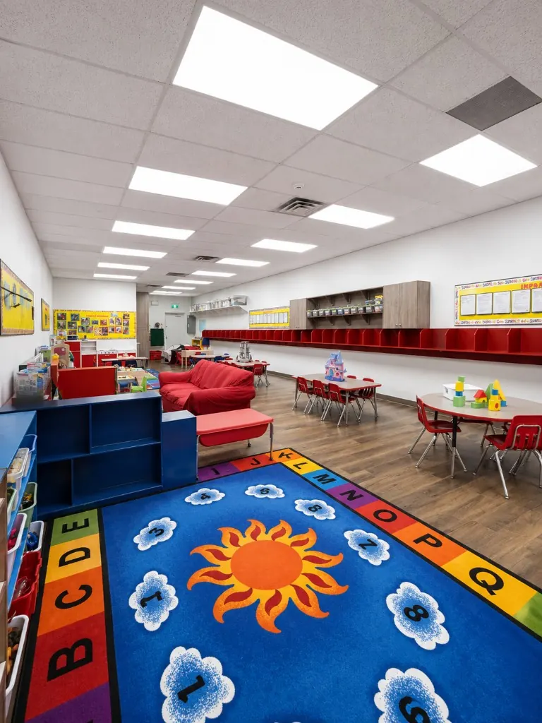Preschool room with a large alphabet and sun rug and reading corner